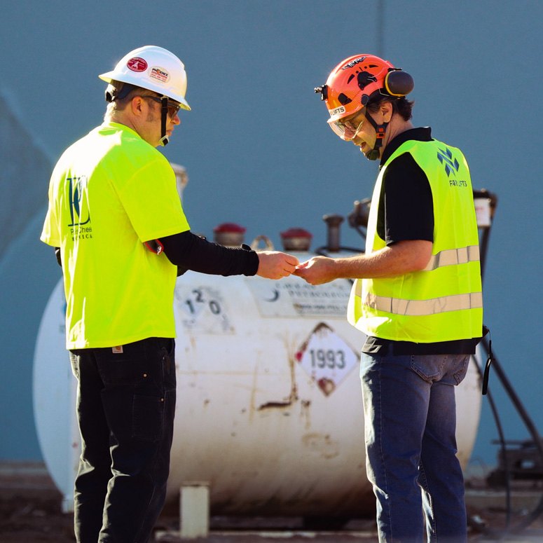 Erran F. Yearty on a helicopter jobsite beside a white Huey