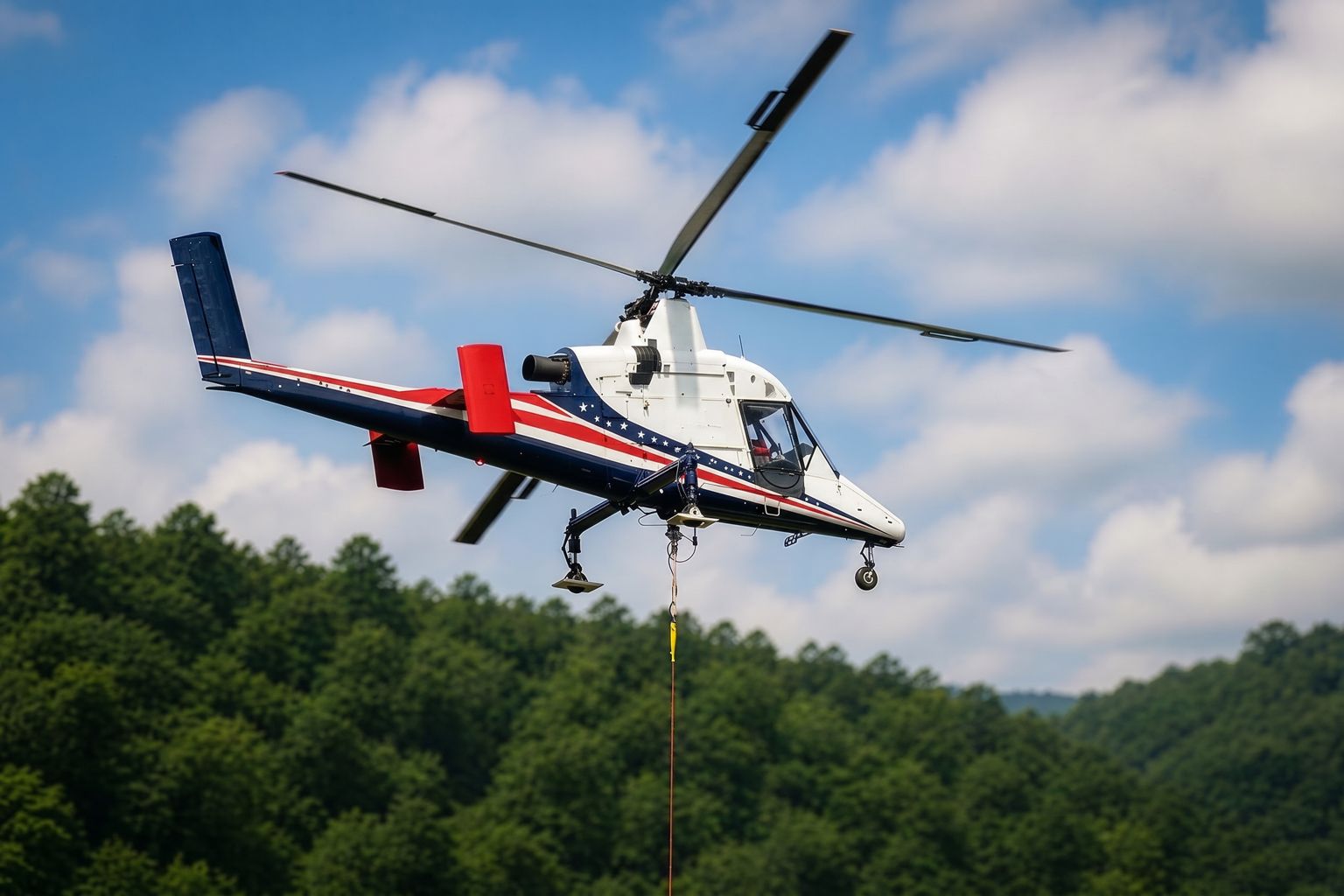Kaman K-MAX flying a longline over forested ridge terrain, the airframe that lifts more than its own empty weight