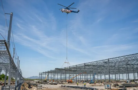 Helicopter carrying a structural steel member on an external line